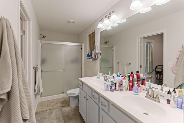 bathroom featuring tile patterned floors, vanity, toilet, and an enclosed shower