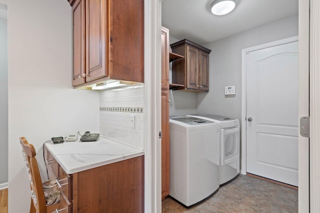 clothes washing area featuring cabinet space and washer and clothes dryer