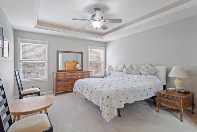 bedroom featuring a ceiling fan, a raised ceiling, light colored carpet, and baseboards