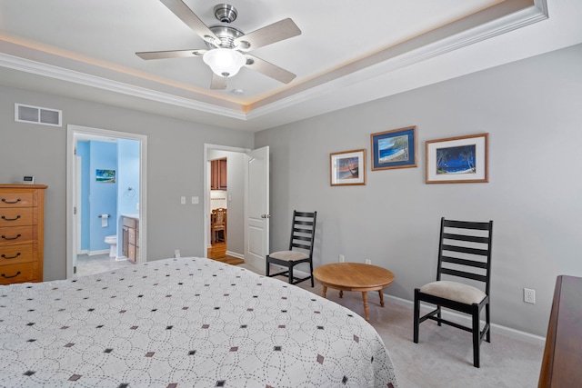 bedroom with a raised ceiling, visible vents, light carpet, ensuite bath, and baseboards