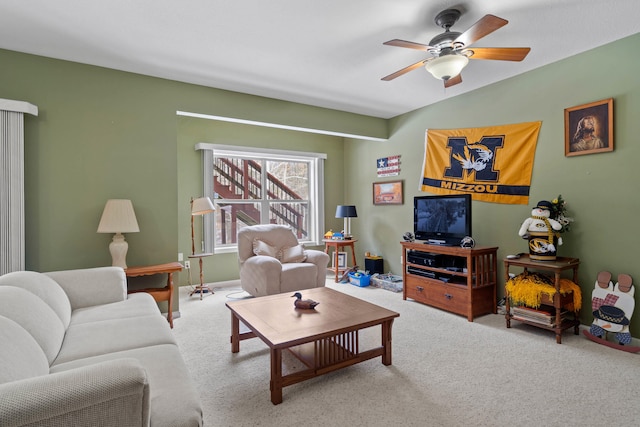 carpeted living area with a ceiling fan