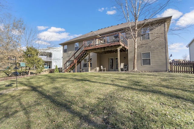 rear view of property featuring a wooden deck, stairs, fence, and a yard