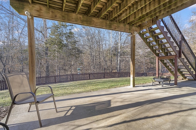 view of patio with fence, a fire pit, and stairs