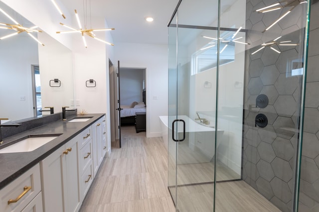 bathroom featuring vanity, a healthy amount of sunlight, a shower with door, and a notable chandelier