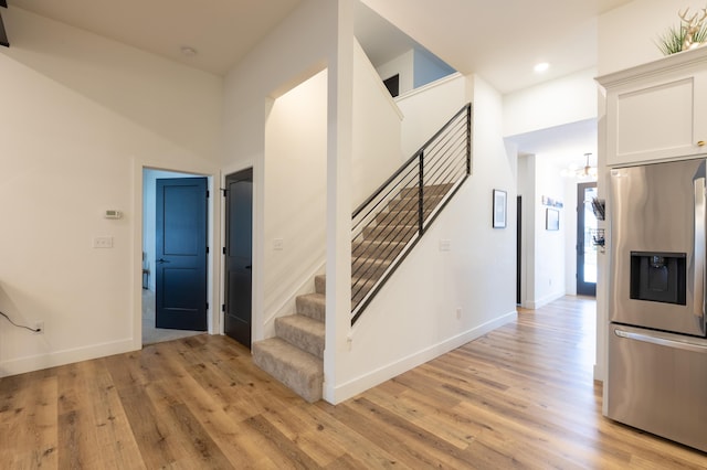 staircase with a chandelier and hardwood / wood-style floors