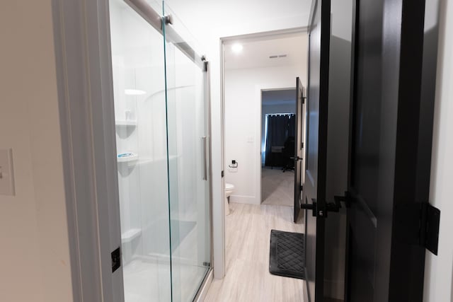 bathroom featuring walk in shower and toilet