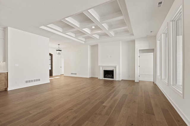 unfurnished living room featuring an inviting chandelier, dark hardwood / wood-style flooring, beam ceiling, and coffered ceiling