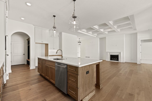 kitchen with dishwasher, an island with sink, sink, beam ceiling, and coffered ceiling