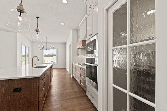 kitchen with a center island with sink, stainless steel appliances, white cabinets, and sink