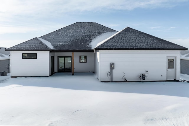 view of snow covered rear of property