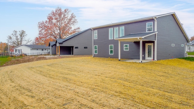 rear view of house featuring a lawn and a patio area