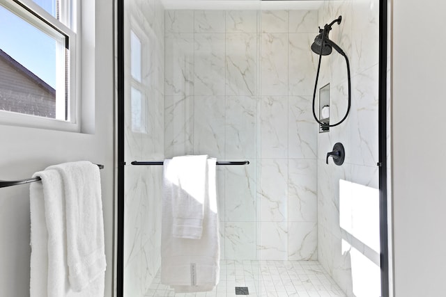 bathroom featuring a marble finish shower