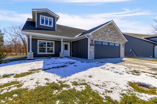 view of front facade featuring an attached garage, stone siding, and board and batten siding