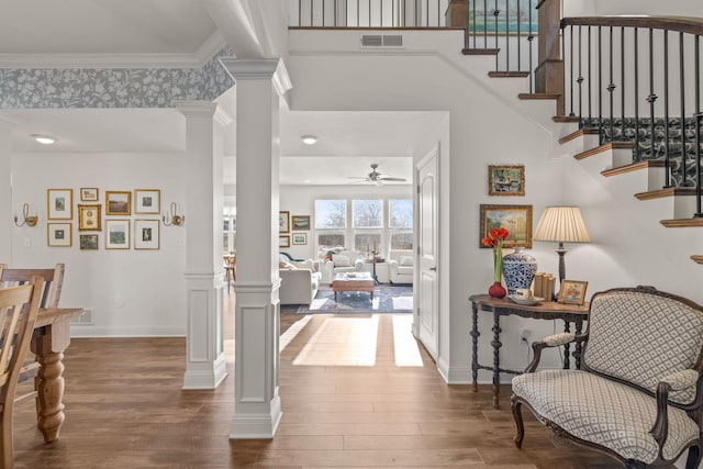 foyer with ornate columns, ornamental molding, ceiling fan, and dark hardwood / wood-style flooring