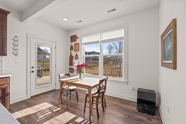 dining area featuring beamed ceiling, dark hardwood / wood-style floors, and heating unit