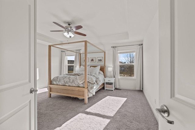 bedroom with ceiling fan, a raised ceiling, and carpet