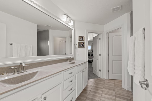 bathroom featuring vanity, tile patterned flooring, and a textured ceiling