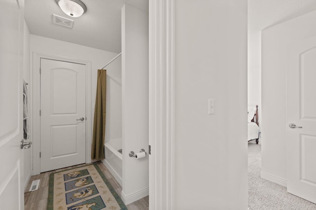 bathroom with shower / bathing tub combination and a textured ceiling