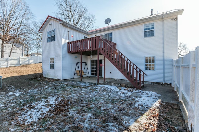 snow covered rear of property featuring a wooden deck