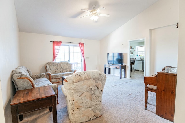 living room featuring ceiling fan, carpet floors, and lofted ceiling