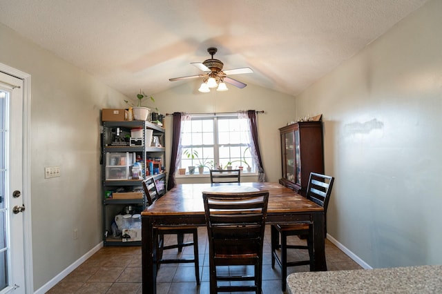 tiled dining room featuring ceiling fan, a textured ceiling, and lofted ceiling