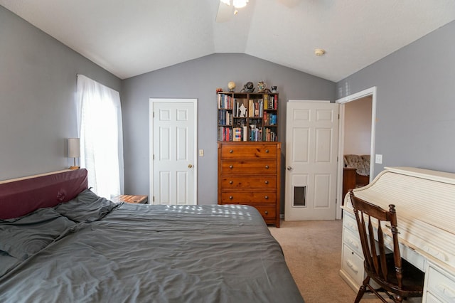 carpeted bedroom with ceiling fan and vaulted ceiling