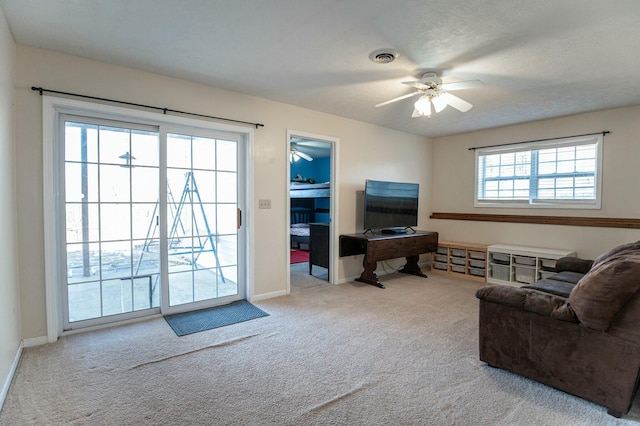 carpeted living room with ceiling fan