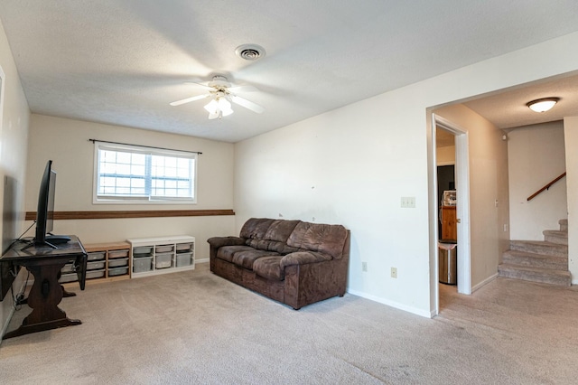 carpeted living room with ceiling fan and a textured ceiling