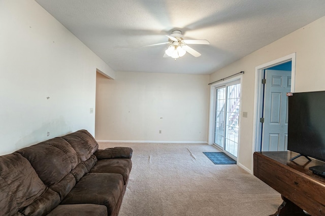 living room featuring light carpet, a textured ceiling, and ceiling fan