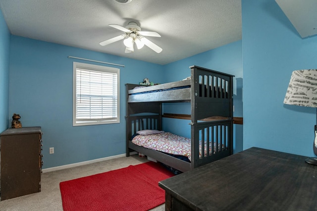 bedroom with ceiling fan, a textured ceiling, and light carpet