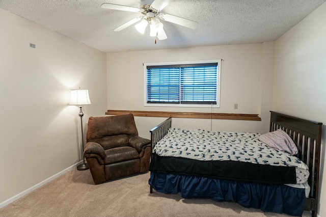 bedroom with a textured ceiling, light colored carpet, and ceiling fan