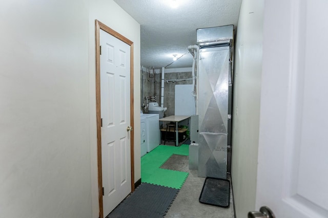 corridor with a textured ceiling and washer and dryer