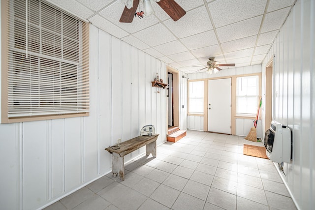 interior space with heating unit, ceiling fan, and a paneled ceiling