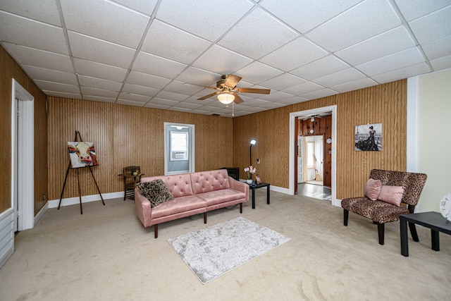 carpeted living room with ceiling fan and a paneled ceiling