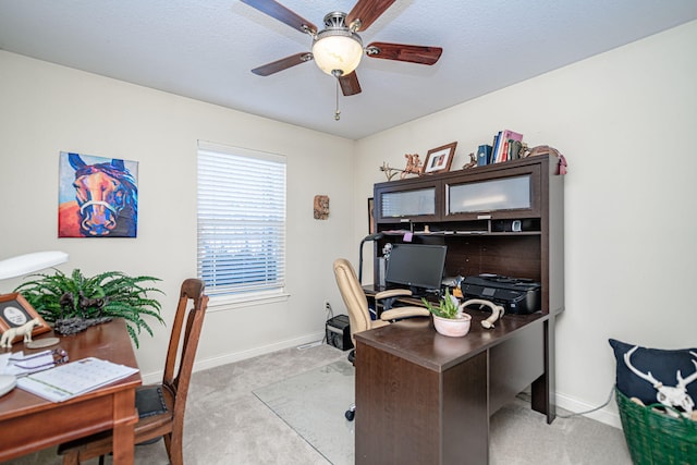 carpeted office space featuring ceiling fan