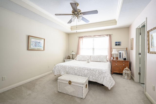 carpeted bedroom featuring ceiling fan, crown molding, a raised ceiling, and a textured ceiling