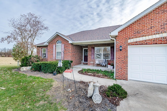 single story home featuring a garage, a front yard, and a porch