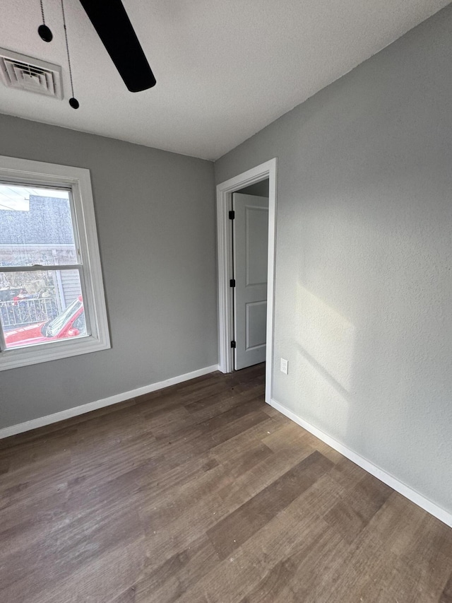 spare room with ceiling fan and dark hardwood / wood-style flooring