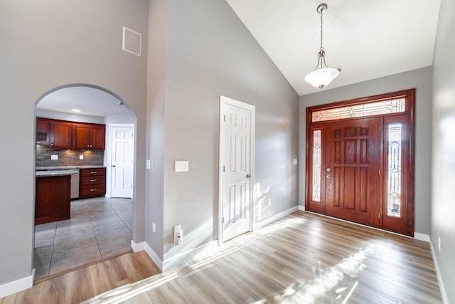 foyer featuring dark wood-type flooring and high vaulted ceiling