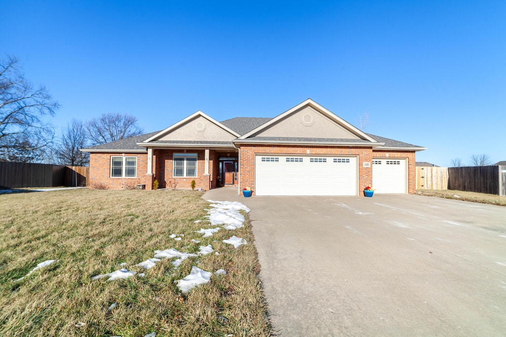 ranch-style home with a garage and a front yard