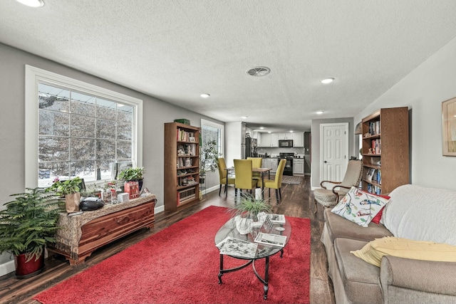 living room with dark hardwood / wood-style flooring and a textured ceiling