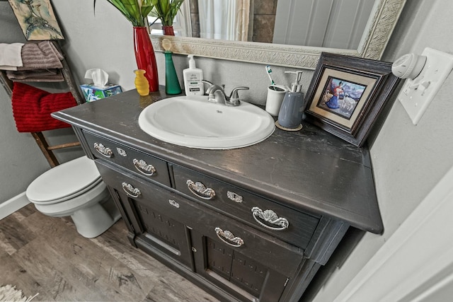 bathroom with vanity, wood-type flooring, and toilet