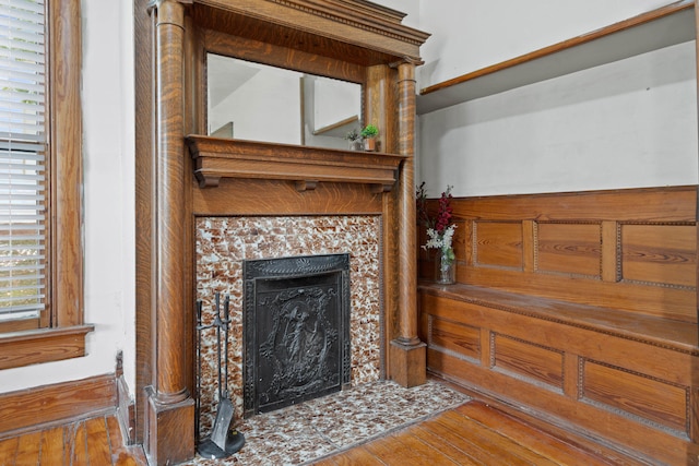 living room featuring a tiled fireplace, plenty of natural light, and hardwood / wood-style flooring