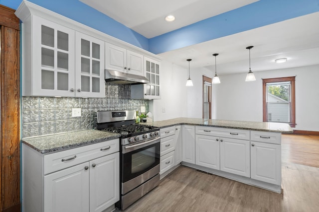 kitchen featuring kitchen peninsula, stainless steel range with gas stovetop, and white cabinets