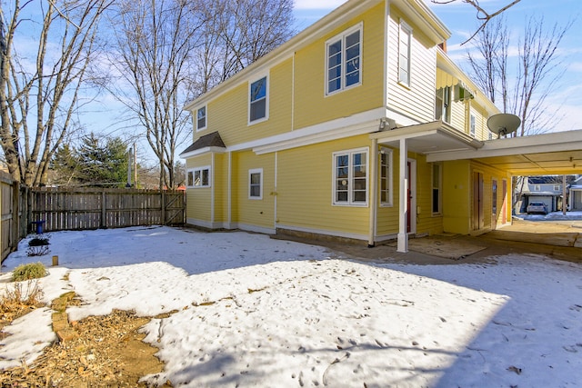 snow covered property with a carport