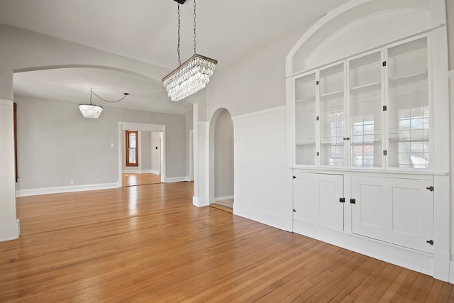 unfurnished dining area featuring a chandelier and light hardwood / wood-style floors