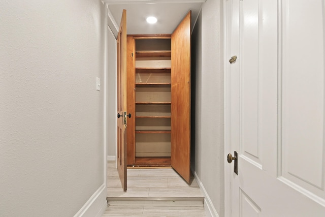 corridor with light hardwood / wood-style flooring