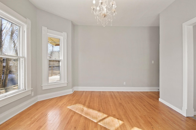 unfurnished dining area featuring an inviting chandelier and light hardwood / wood-style floors