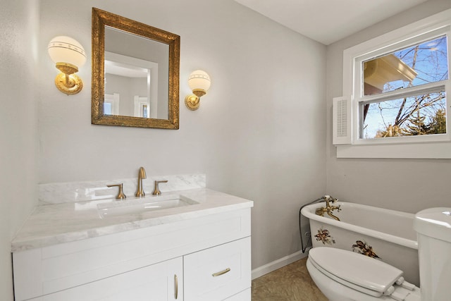 bathroom with vanity, a tub to relax in, and toilet