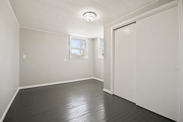 unfurnished bedroom with dark hardwood / wood-style floors and a closet